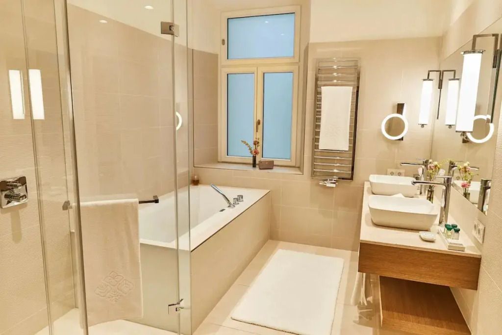 Helles Badezimmer mit Badewanne und Doppelwaschbecken in der Suite.