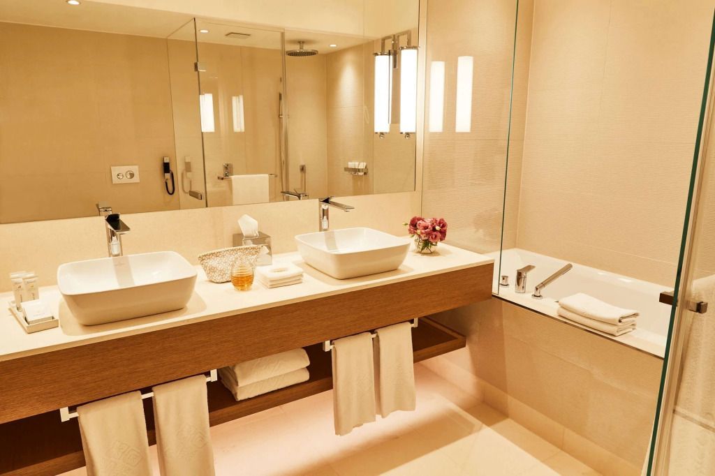 Helles Badezimmer mit Doppelwaschbecken und großen Spiegeln in elegantem Design