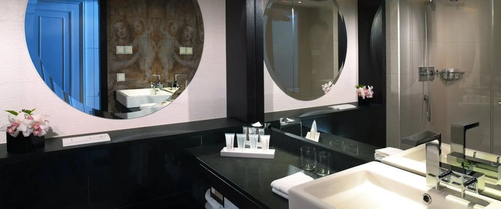 Luxuriöses Badezimmer mit großen Spiegeln und hochwertigen Pflegeprodukten
