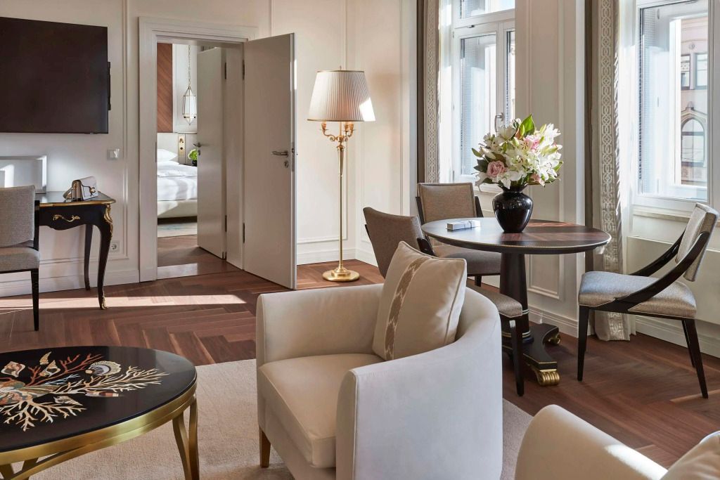 Wohnbereich mit gemütlichem Sessel und stilvoller Dekoration in der Signature Suite des Hotel Vier Jahreszeiten Kempinski München