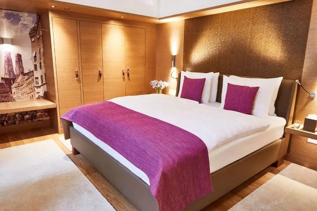 Modernes Hotelzimmer mit Doppelbett und rosa Akzenten in der Superior Suite