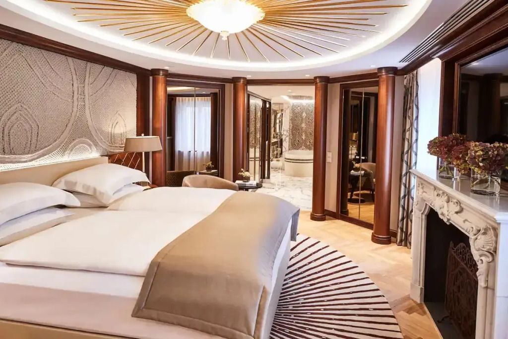 Luxuriöse Suite mit elegantem Doppelbett und kunstvoller Deckenverzierung