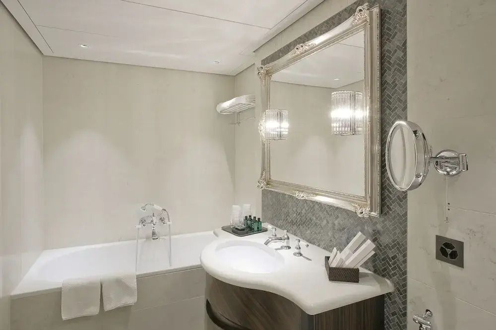 Elegantes Badezimmer mit großer Badewanne und stilvollem Spiegel