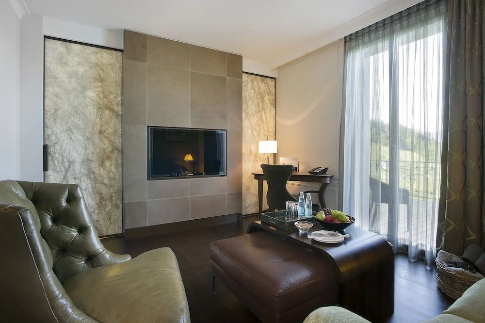 Wohnbereich einer Suite mit Kamin und Zugang zum Balkon