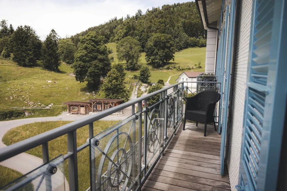 Balkon mit Blick auf grüne Berge und Wiesen
