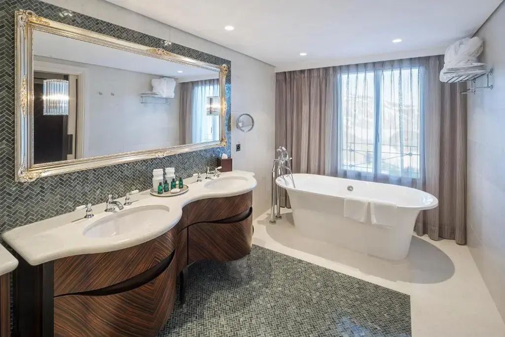 Großes Badezimmer mit freistehender Badewanne und großzügiger Beleuchtung