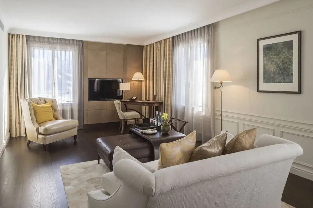 Bequemes Wohnzimmer mit Sitzbereich und Schreibtisch im Hotelzimmer