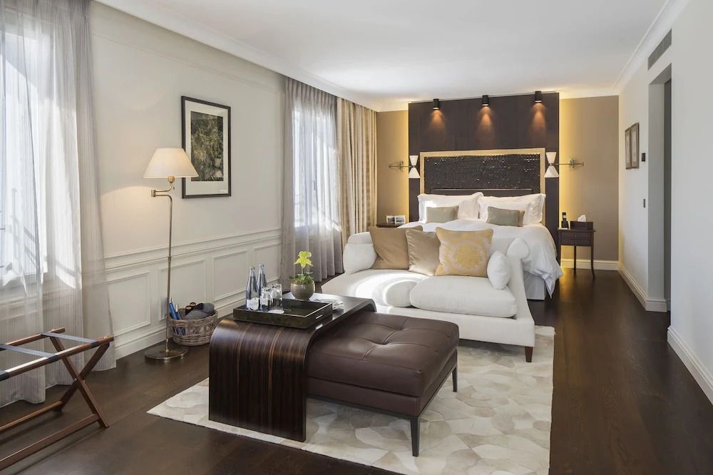 Elegantes Hotelzimmer mit Doppelbett, Sofa und stilvollen Möbeln