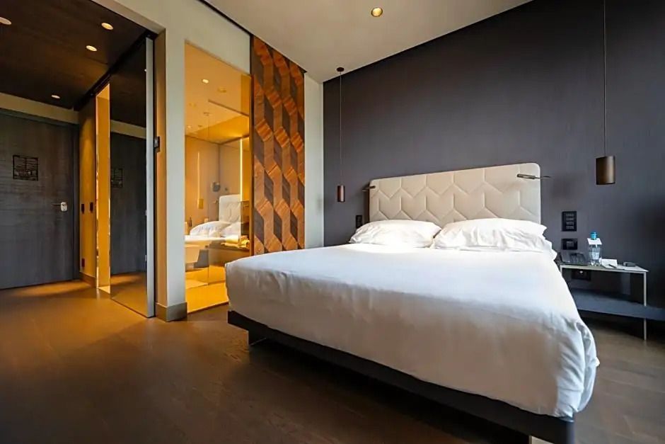 Modernes Doppelzimmer mit eleganter Beleuchtung und großem Bett im Hotel Viu Milan