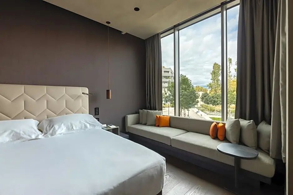 Gemütliches Doppelzimmer mit großem Fenster und eleganter Sitzecke im Hotel Viu Milan