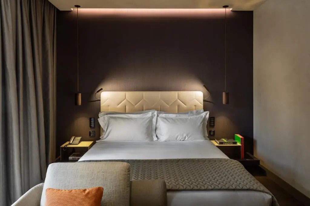 Luxuriöses Doppelbett in modernem Zimmer mit gedämpfter Beleuchtung