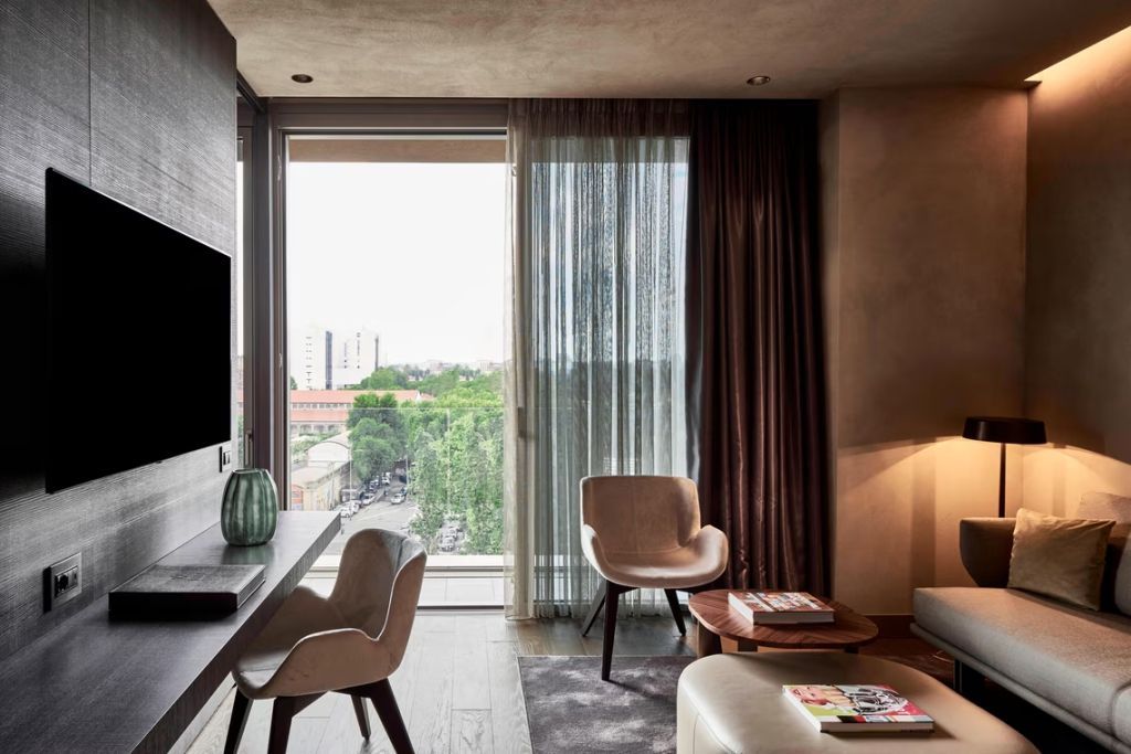 Geräumige Suite mit großem Fenster und stilvollen Möbeln.