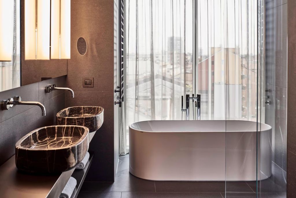Modernes Badezimmer mit freistehender Badewanne und zwei Waschbecken in der Suite.