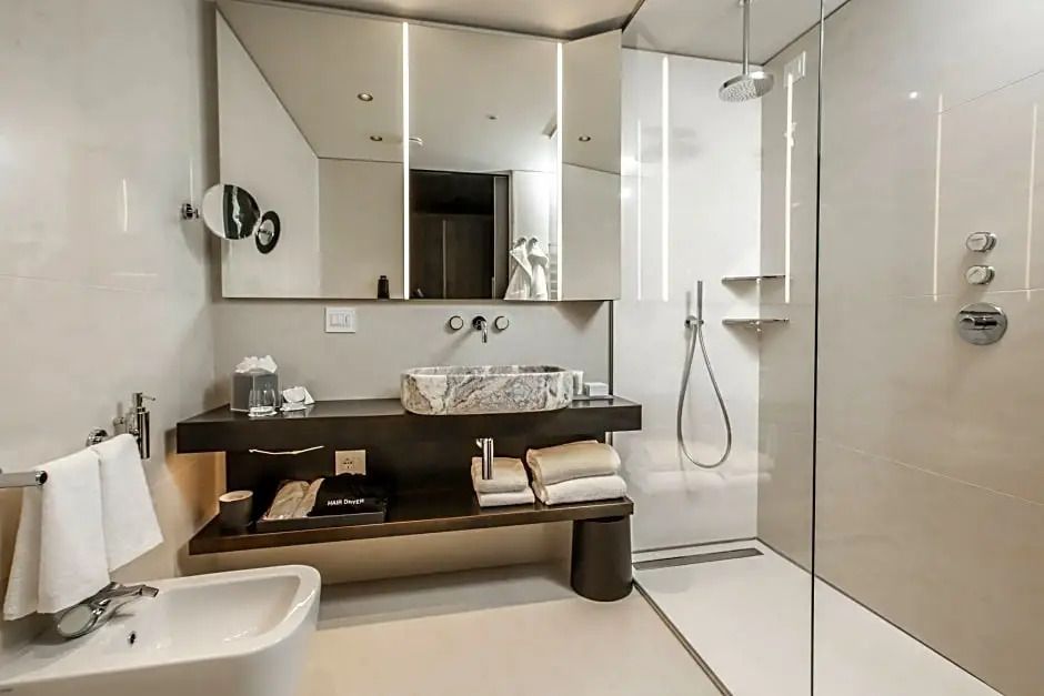 Luxuriöses Badezimmer mit Marmorwaschbecken und Regendusche