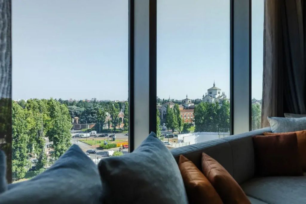 Weite Aussicht durch große Fenster von der Sitzecke eines Hotelzimmers.