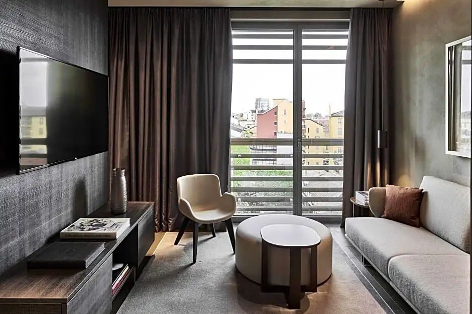 Stilvoll eingerichtetes Zimmer mit Sitzecke und Blick auf die Stadt