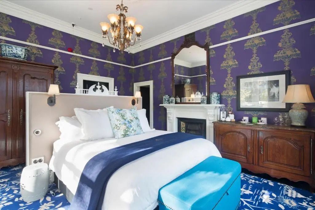 Luxuriöses Schlafzimmer mit klassischem Kamin und edlen Farben