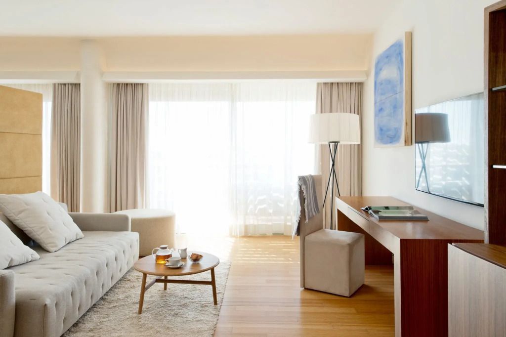 Helle Sitzecke mit Designer-Möbeln und großem Fenster in der Suite