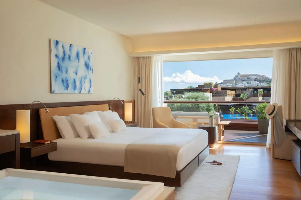 Geräumige Junior-Suite mit Doppelbett und Balkon mit Blick auf die Stadt
