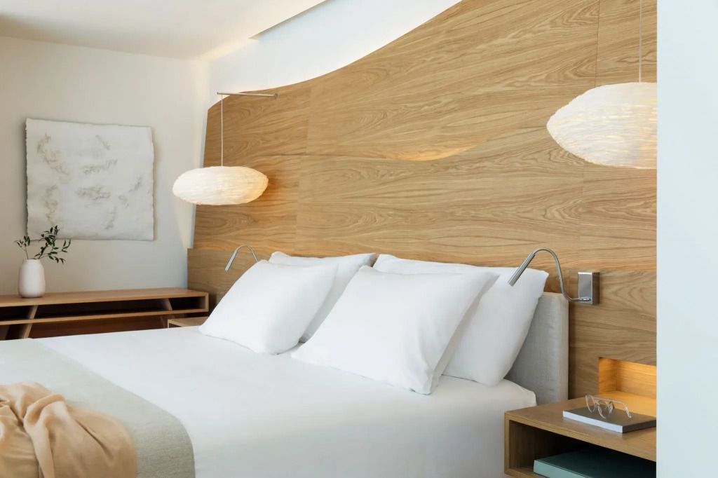 Elegantes Doppelbett in moderner Suite mit Holzakzenten und stilvoller Beleuchtung