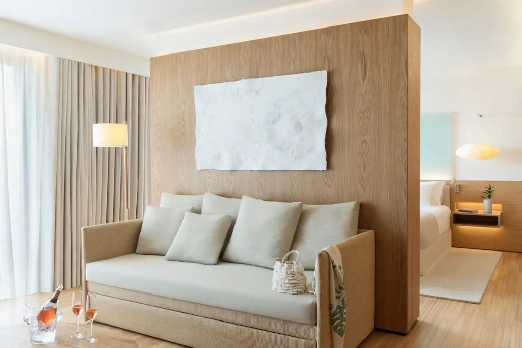 Gemütlicher Sitzbereich mit Sofa und Kunstwerk an der Wand in der Suite