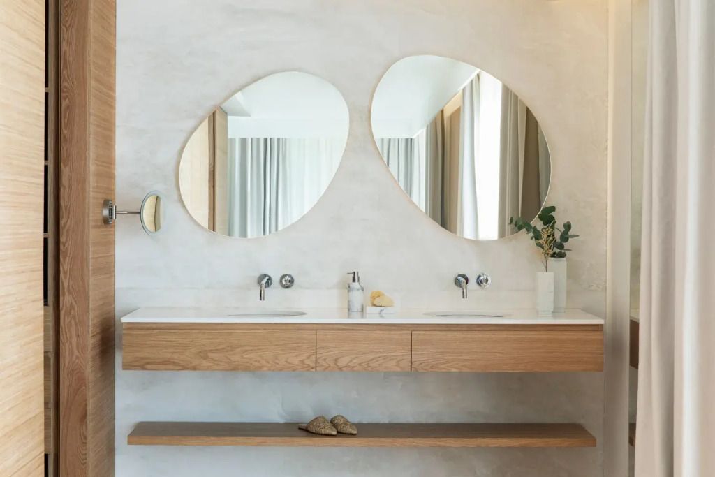 Stylisches Badezimmer mit ovalen Spiegeln und minimalistischer Einrichtung
