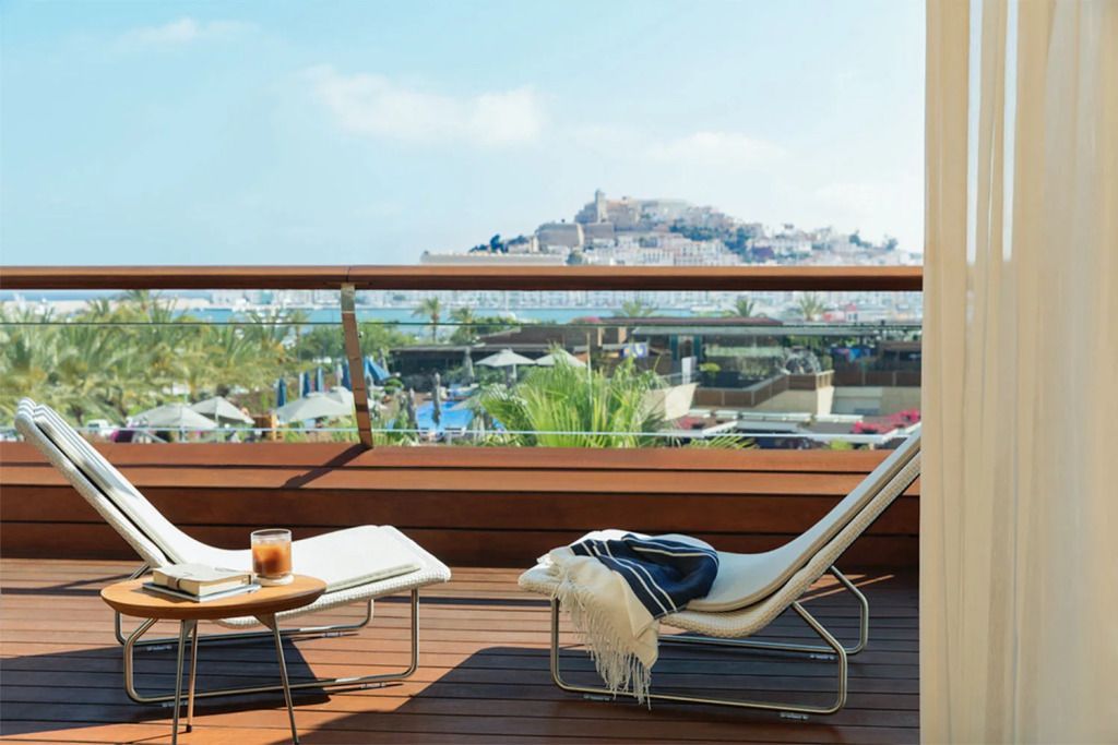 Balkon mit Liegestühlen und Blick auf die Stadt Ibiza