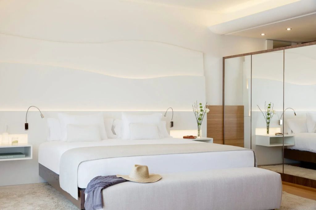 Elegantes Zimmer mit Doppelbett und moderner Einrichtung in neutralen Farben