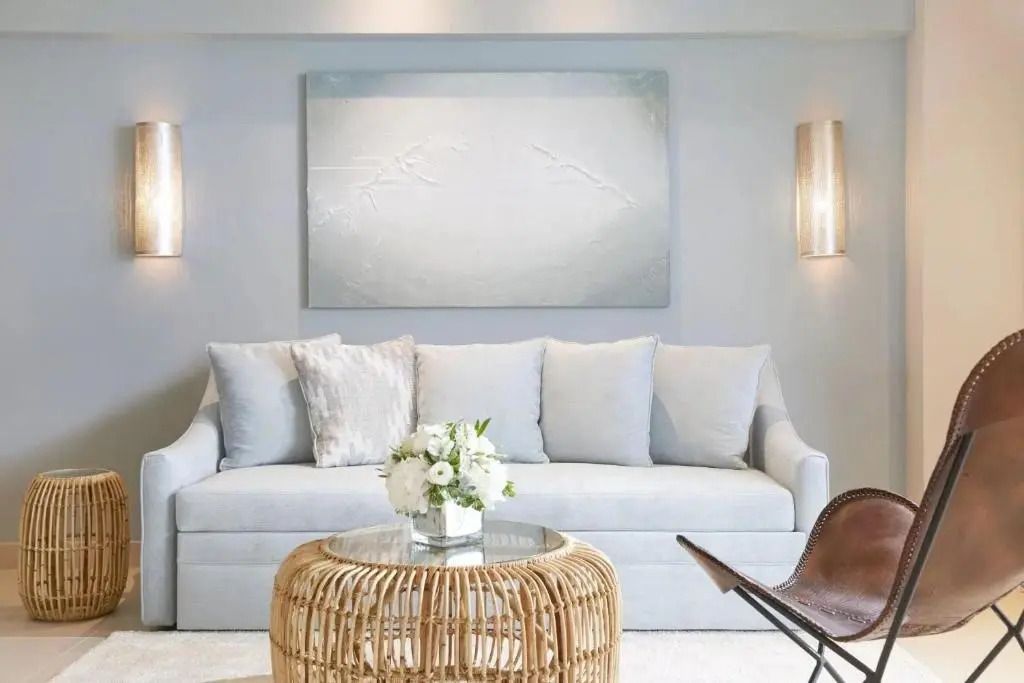 Stilvolles Wohnzimmer mit hellen Sofas und Kunst an der Wand.