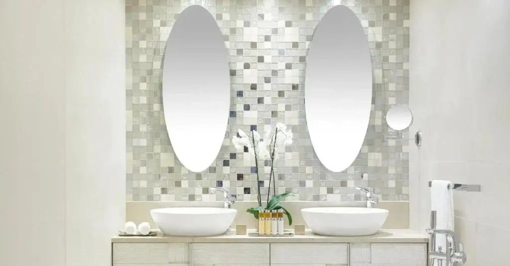 Luxuriöses Badezimmer mit modernen Doppelwaschbecken und ovalen Spiegeln.
