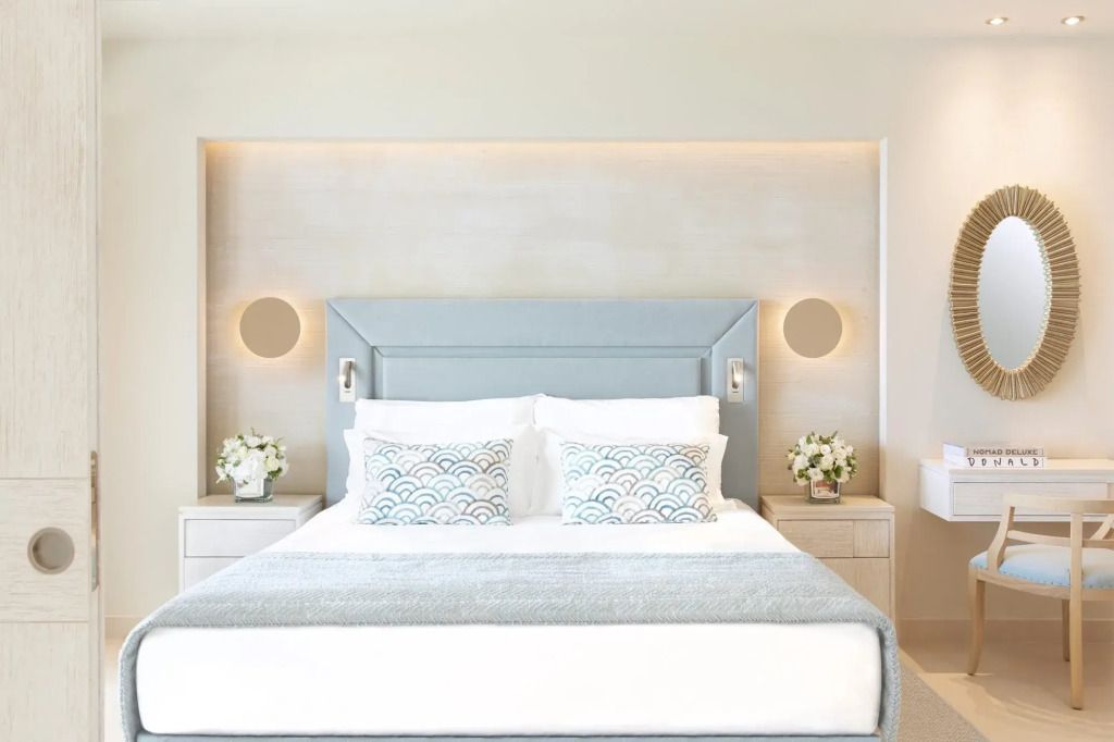 Elegantes Doppelbett mit stilvollen Kissen in heller, moderner Suite.