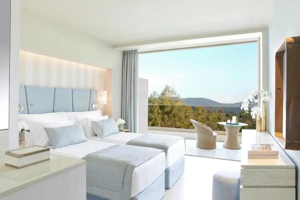 Helles Familienzimmer mit zwei Betten und großem Fenster mit Blick ins Innenland