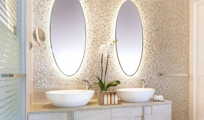 Luxuriöses Badezimmer mit doppeltem Waschbecken und stilvollen Spiegeln.