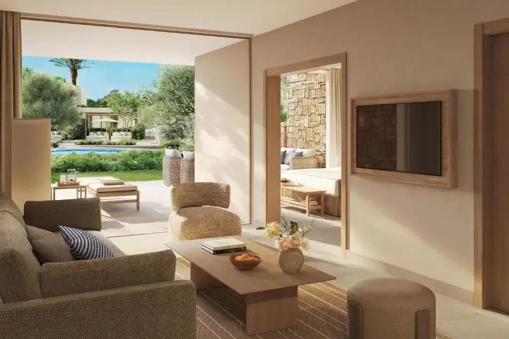 Modernes Wohnzimmer mit Blick auf den Garten und Pool im Hotelzimmer.