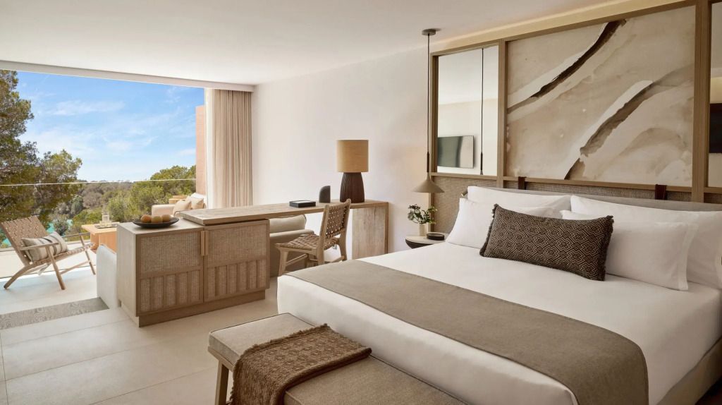Luxuriöse Junior-Suite mit Doppelbett und Blick auf den Garten
