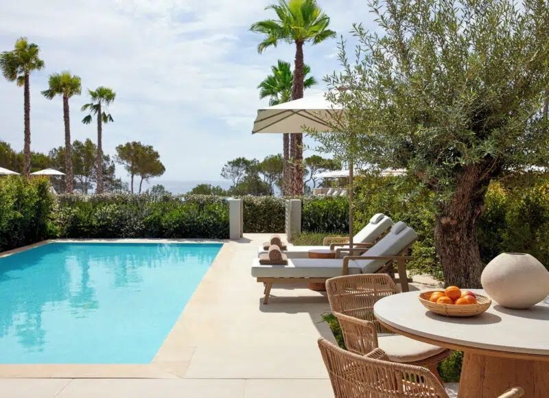 Privater Poolbereich mit Liegestühlen und Tisch mit Blick auf das Meer