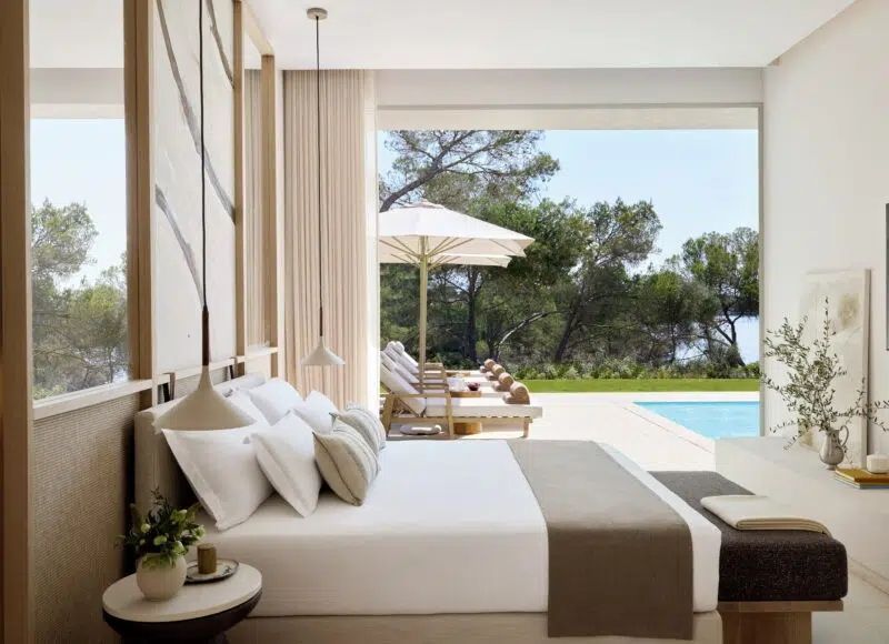 Modernes Schlafzimmer mit großen Fenstern und Blick auf Pool und Garten