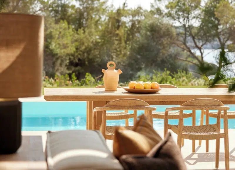 Terrasse mit Poolblick und stilvollen Sitzgelegenheiten im Freien