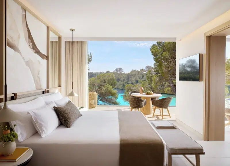 Elegantes Schlafzimmer mit Doppelbett und traumhaftem Poolblick durch große Fenster