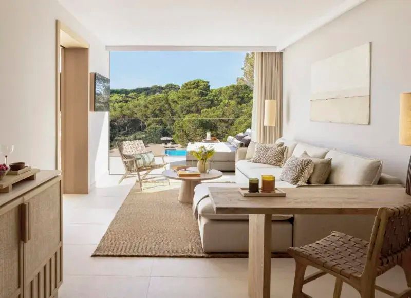 Geräumiger Wohnbereich mit Blick auf den privaten Pool und grüne Natur