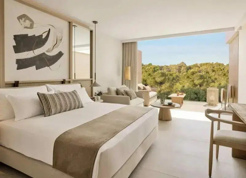 Modern eingerichtetes Doppelzimmer mit Doppelbett und Aussicht auf Natur