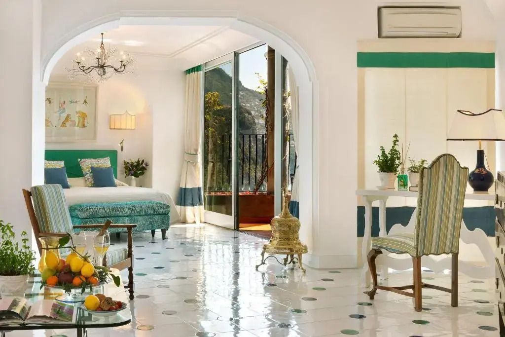 Helle Junior-Suite mit Blick auf Terrasse und Meer, eleganter Einrichtung und Pflanzen