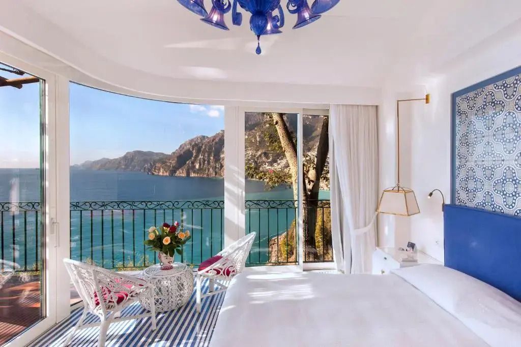 Zimmer mit Balkon und Ausblick auf Meer und Berge, stilvolle Einrichtung