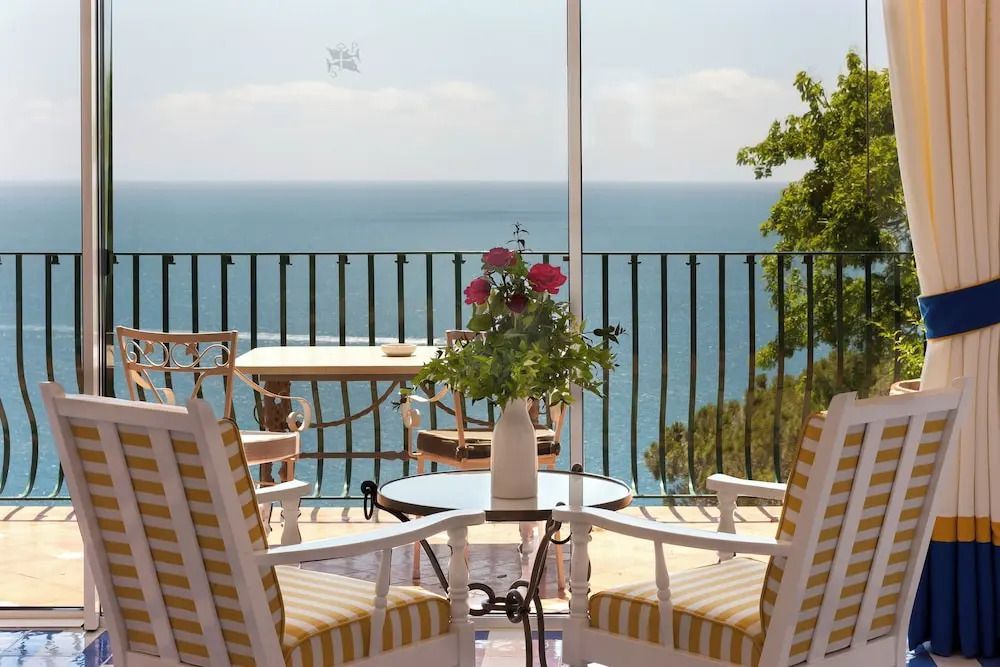 Terrasse mit Sitzbereich und Blick auf das Meer und grüne Landschaft