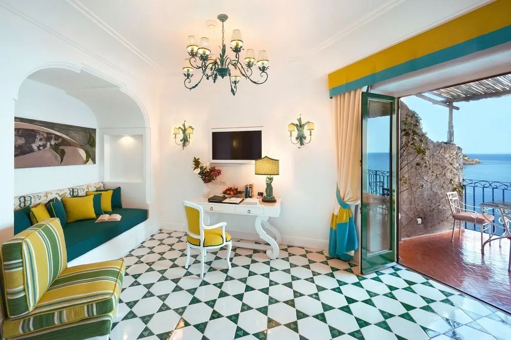 Elegantes Zimmer mit Schreibtisch und kleinem Balkon mit Meerblick
