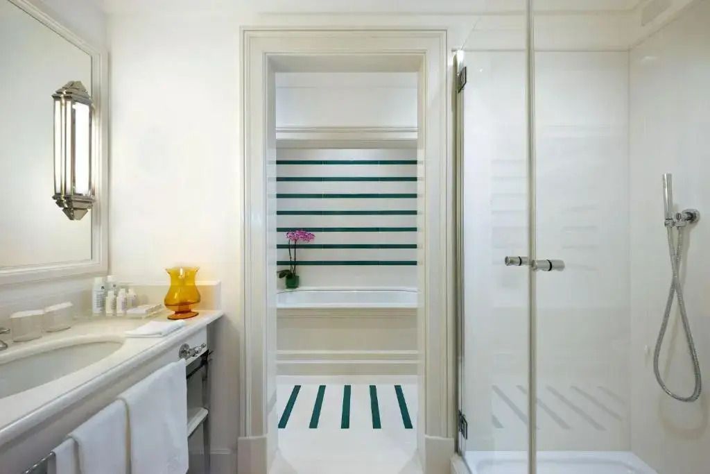 Modernes Badezimmer mit Duschkabine und dezentem Blumenschmuck.