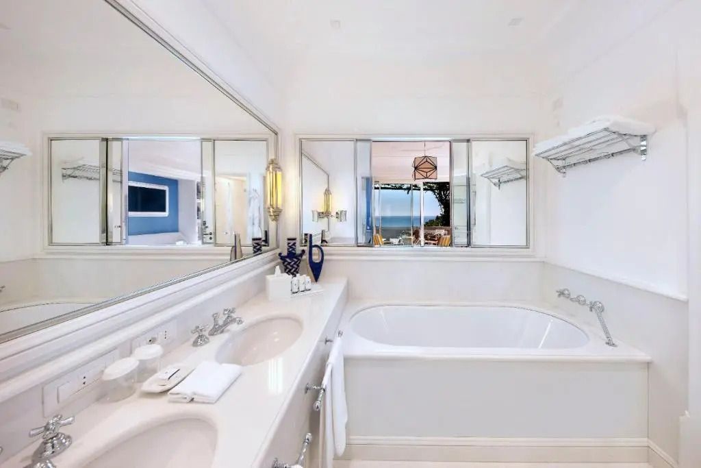 Geräumiges Badezimmer mit Badewanne und großem Spiegel.