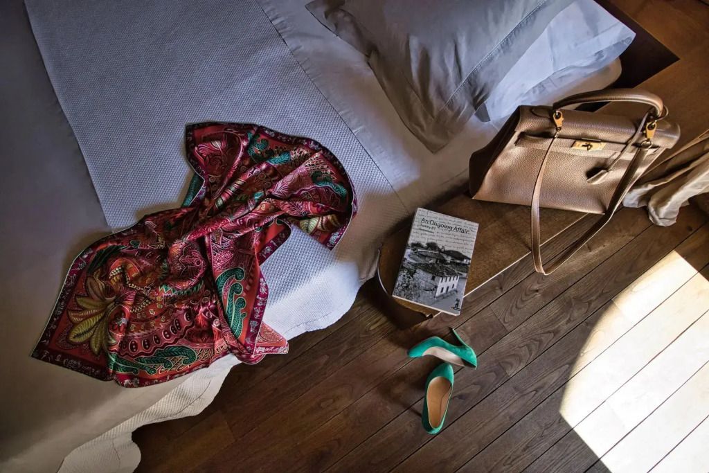 Hochwertige Tasche und Zeitschrift auf dem Bett in luxuriösem Zimmer