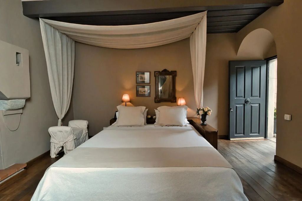 Elegantes Doppelbett mit Baldachin und warmem Licht im Treasure Doppel Zimmer.