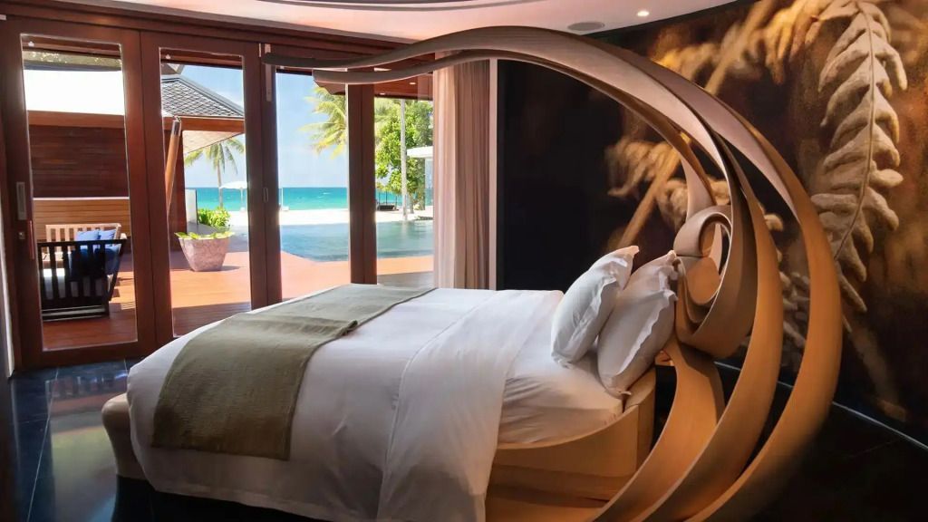 Luxuriöse Suite mit doppeltem Himmelbett und Meerblick durch große Fenster.